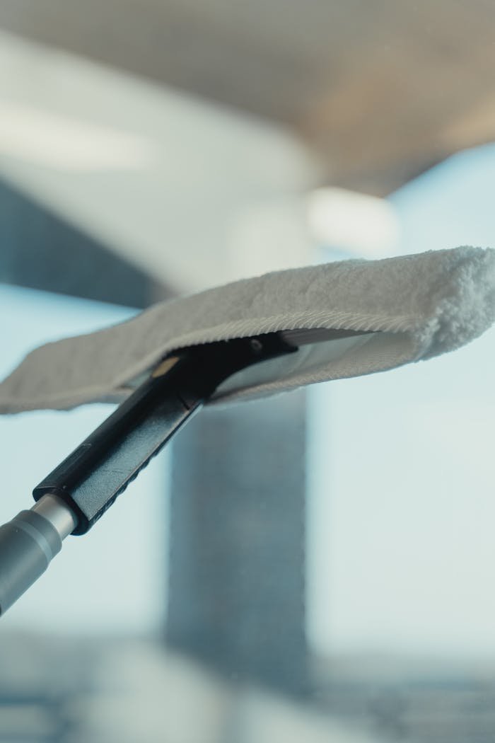 Close-up of a cleaning tool on a window showcasing maintenance and sanitation.